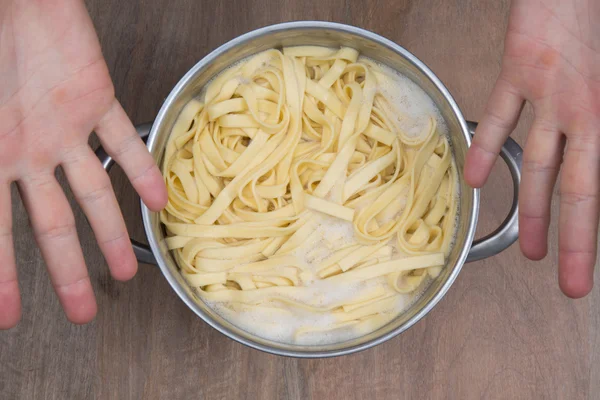 Um tema de comida: macarrão em água fervente . — Fotografia de Stock