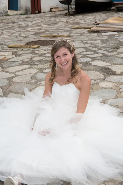 Sexy bride sitting on the ground in a funny way — Stock Photo, Image