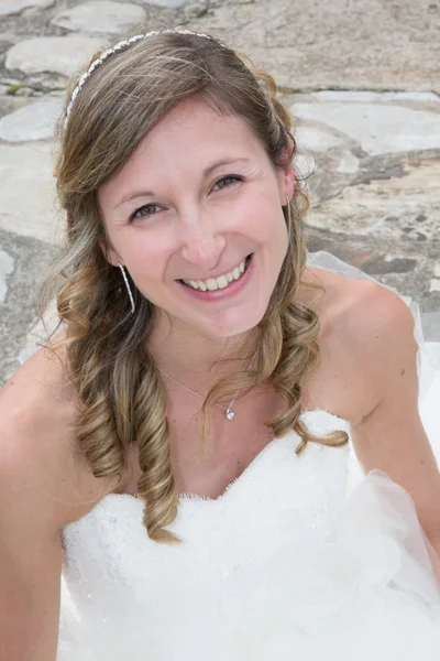 Yeni gelin kameraya bakarak onun elbisesi ile