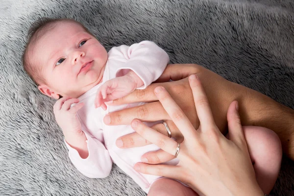 Primer plano del bebé recién nacido con las manos en el vientre de los padres —  Fotos de Stock