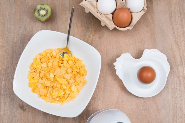 脆玉米片加牛奶，鸡蛋，木制的棕色背景 — 图库照片