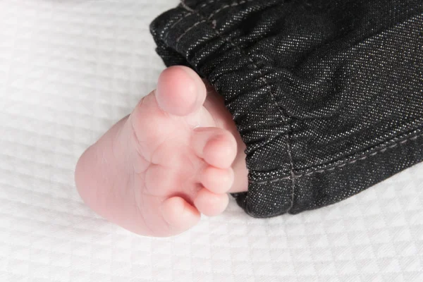Babyfüße mit Hose auf weißem Hintergrund — Stockfoto