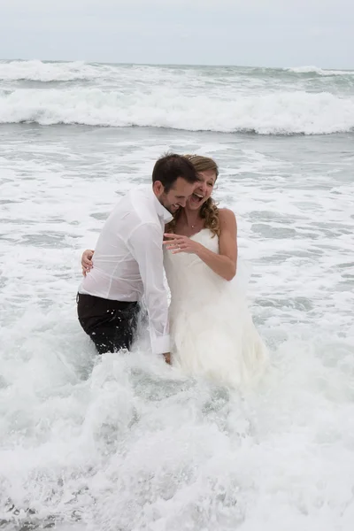 Lovely and Happy newlywed couple standing in water. — Stockfoto