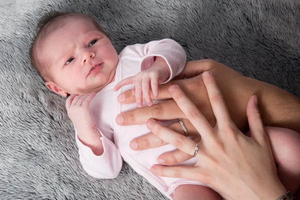Close up of new born baby with parents hands on belly — Stock Photo, Image