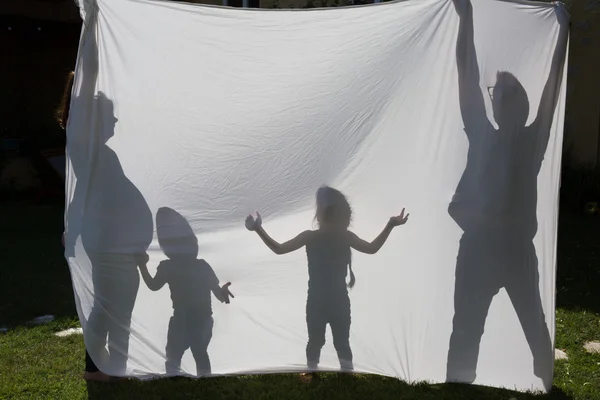 Shadows of a family behind a sheet -Symbol of a family