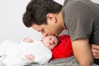 Yeni doğan bebek alnını öpmek baba