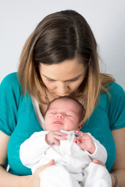 Mutter hält ihr neugeborenes Baby und lächelt in die Kamera — Stockfoto