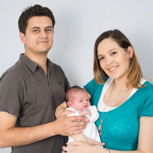 Schöne und glückliche Familie mit ihrem ersten Baby — Stockfoto