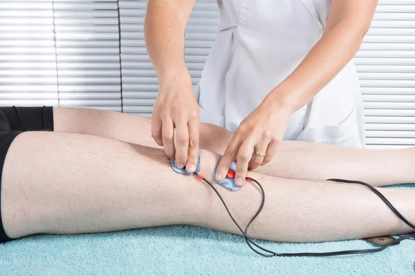 Terapeuta colocando muchos electrodos en el cuerpo — Foto de Stock