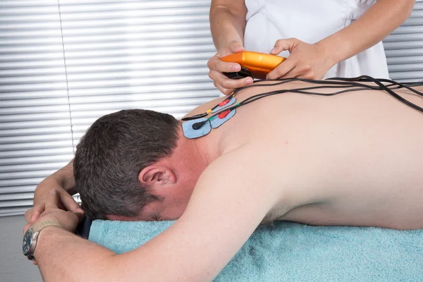 Terapeut uvedení hodně elektrod na těle — Stock fotografie