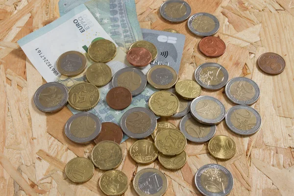 Pièces de monnaie, carte bancaire et argent sur la table sous fond en bois — Photo