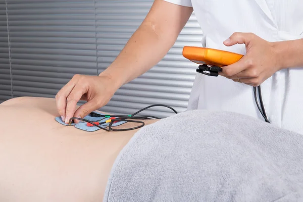 Man with electrostimulator electrodes on his Back — Stock Photo, Image