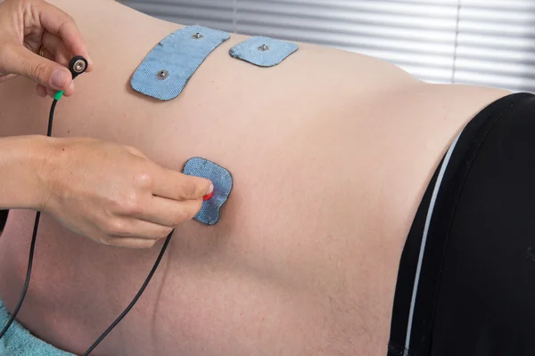 Man met electrostimulator-elektroden — Stockfoto