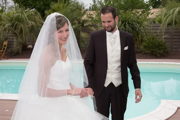 Pareja casada feliz cerca de una piscina —  Fotos de Stock