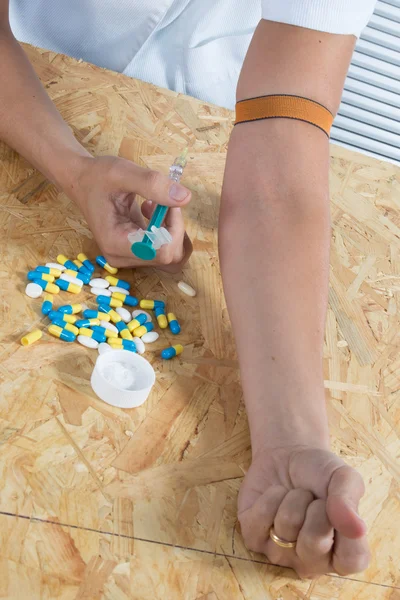 Vrouw met drugsverslaving, pillen en spuit — Stockfoto