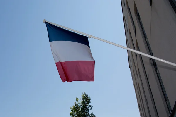 Uma bandeira francesa acenando sobre um céu azul — Fotografia de Stock