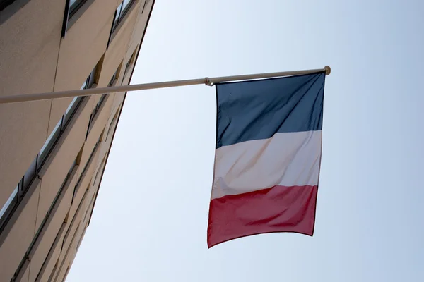 Uma bandeira francesa acenando sobre um céu azul — Fotografia de Stock