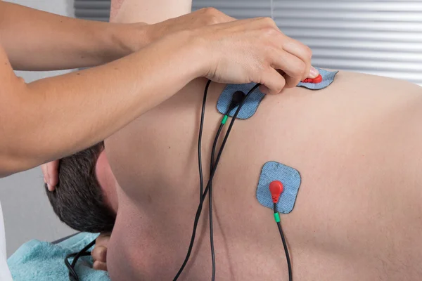 Man with electrostimulator electrodes on his body — Stock Photo, Image