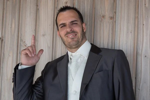 Encantador hombre con una camisa bajo fondo de madera — Foto de Stock