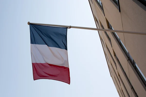 Uma bandeira francesa acenando sobre um céu azul — Fotografia de Stock