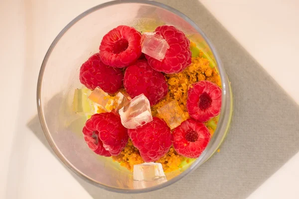 Dessert with raspberries under white plate in a glass — Stock Photo, Image