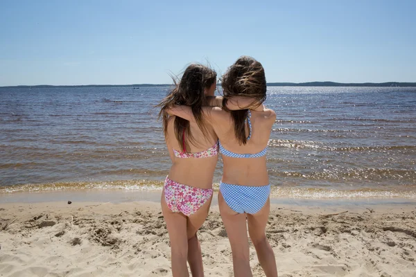 Visão traseira de duas irmãs olhando para o oceano — Fotografia de Stock