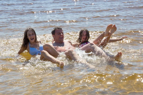 Far och hans två dotter på stranden — Stockfoto