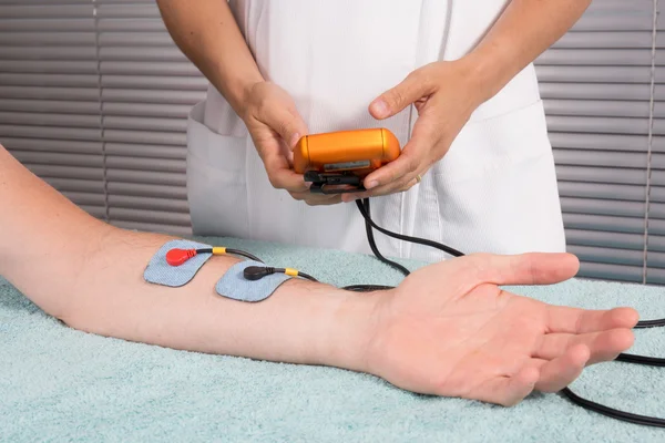 L'homme fait un massage de l'électrostimulateur Procédure médicale . — Photo