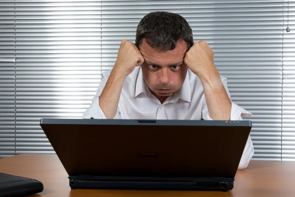 Homem de negócios preocupado segurando a cabeça em seu escritório — Fotografia de Stock