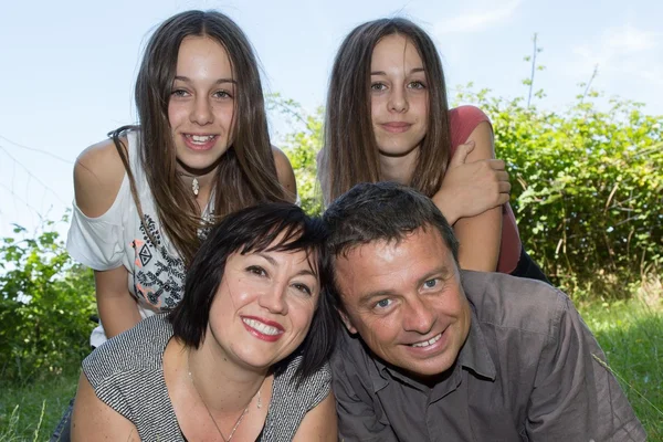 Familie, gelukkige ouders met hun dochters in het park op de zomer — Stockfoto