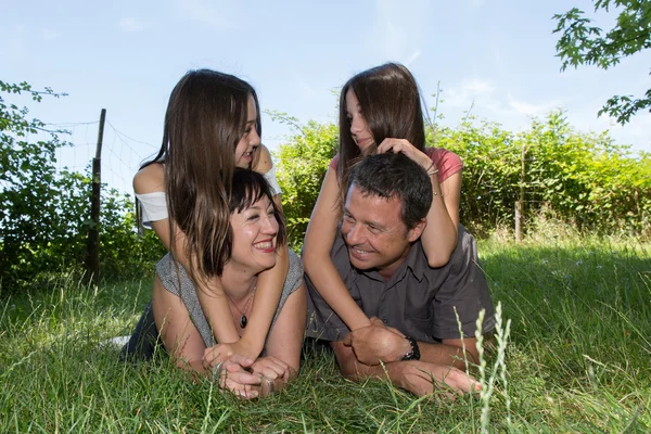 Familie, glückliche Eltern mit ihren Töchtern im Sommer im Park — Stockfoto