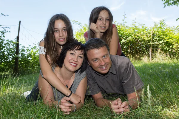 Familie, gelukkige ouders met hun dochters in het park op de zomer — Stockfoto