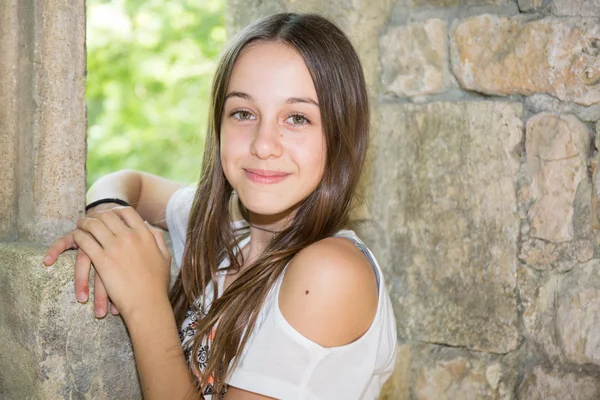 A cute teenage girl of 12 years old smiling at the camera Stock Photo. 