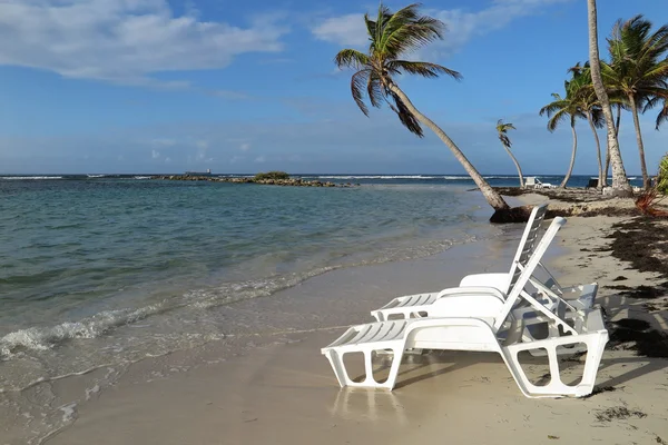 Cadeiras de praia branca na areia com luz solar brilhante — Fotografia de Stock