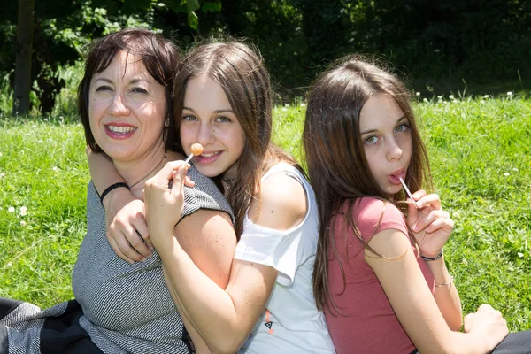 Madre con sus hijas se divierten en la hierba — Foto de Stock