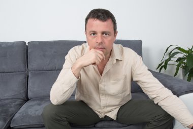 Ev düşüncesinde kanepede oturan rahat bir adam portresi