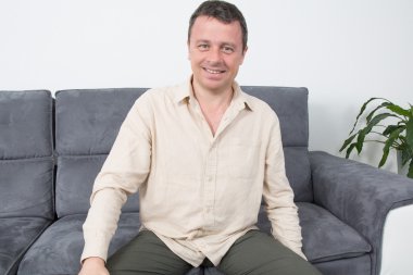 Evde kanepede oturan rahat bir adam portresi