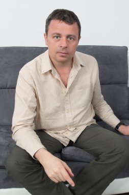 Evde kanepede oturan rahat bir adam portresi