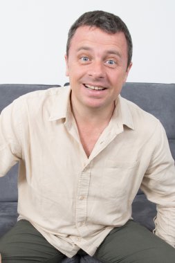 Evde kanepede oturan mutlu ve rahat bir adam portresi