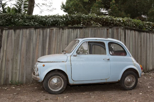 Icônico italiano pequeno carro vintage azul contra fundo de madeira — Fotografia de Stock