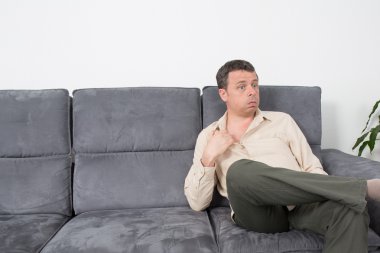 Evde kanepede oturan rahat bir adam portresi