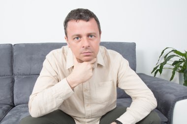 evde kanepede oturan sürpriz bir adam portresi