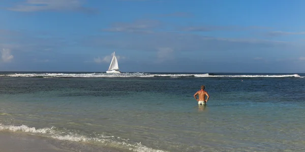Hombre y barco en el mar tropical bajo el cielo azul — Foto de Stock