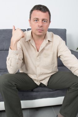 Evde kanepede oturan rahat bir adam portresi