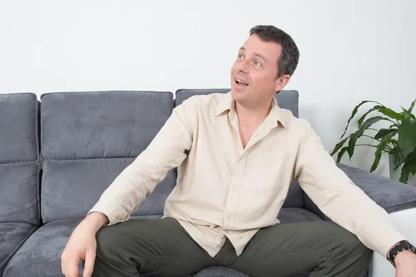 Portrait of a  relaxed man sitting on sofa in the house — Stock Photo, Image