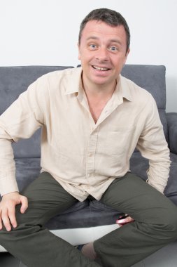 Evde kanepede oturan mutlu ve rahat bir adam portresi