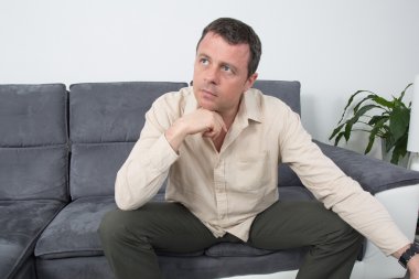 Evde kanepede oturan rahat bir adam portresi