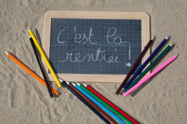 Panneau de retour à l'école sur la plage de sable — Photo