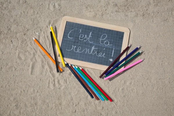 Panneau de retour à l'école sur la plage de sable — Photo