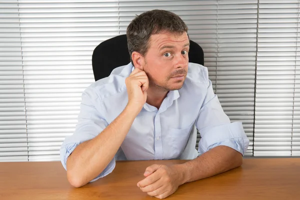 Hombre de negocios estresado sentado en el escritorio sosteniendo la cabeza y preocupándose —  Fotos de Stock